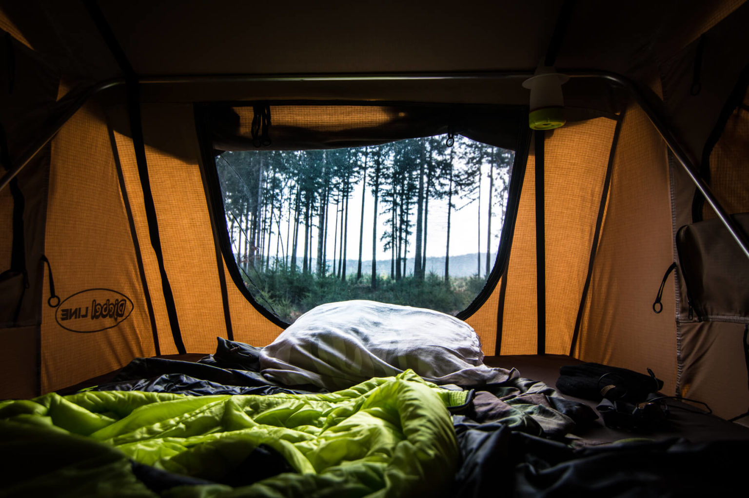 the inside of a roof tent with mattress and bedding