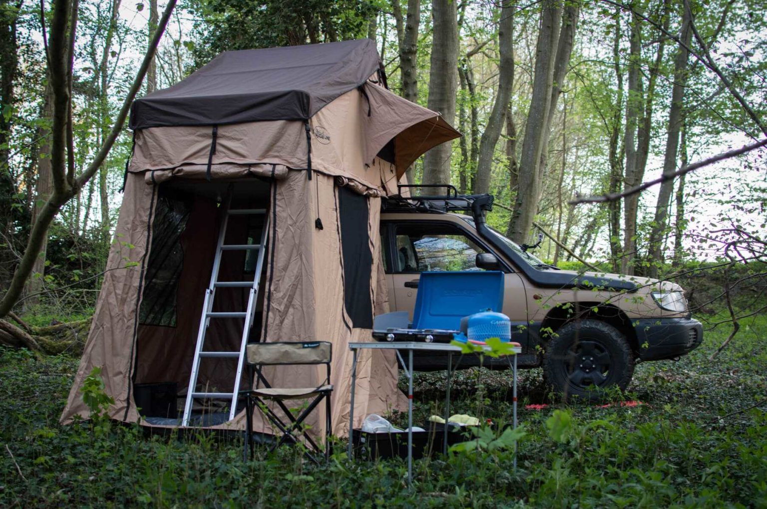 a subaru forester with a roof tent and annex room in the forest